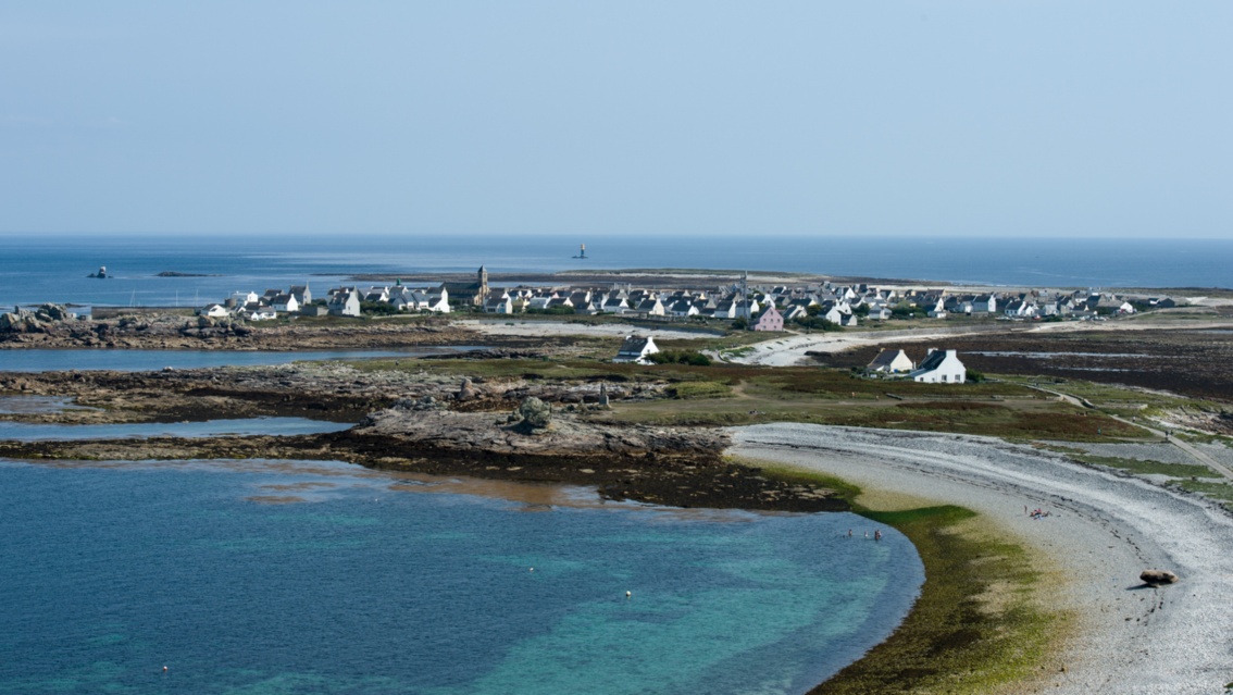 Die Küstenlinie zieht sich im Bogen, im Hintergrund liegt der Ort Île de Sein.