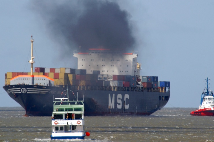 Containerschiff mit schwarzem Dieselqualm