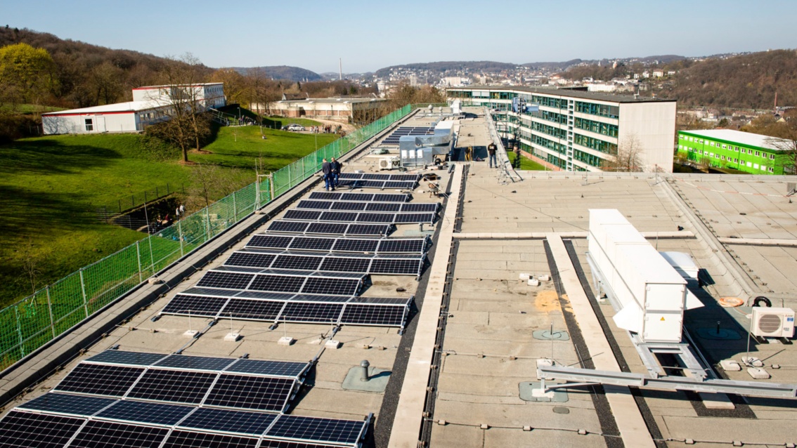 PV Module auf einem Flachdach, im Hintergrund die Stadt Wuppertal.