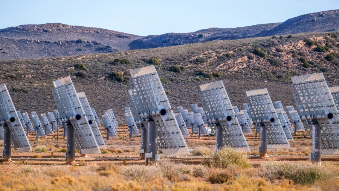 Die großen PV-Module in der Wüste von nahem. Um die Module auf den Sonnenstand auszurichten, sind sie mit Scharnieren an der Tragekonstruktion befestigt.