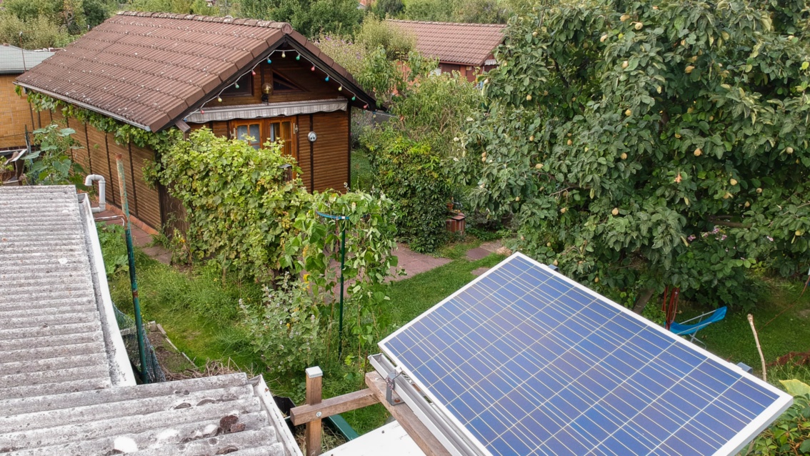 Aerial view of a photovoltaic system installed above an allotment garden house in the countryside.