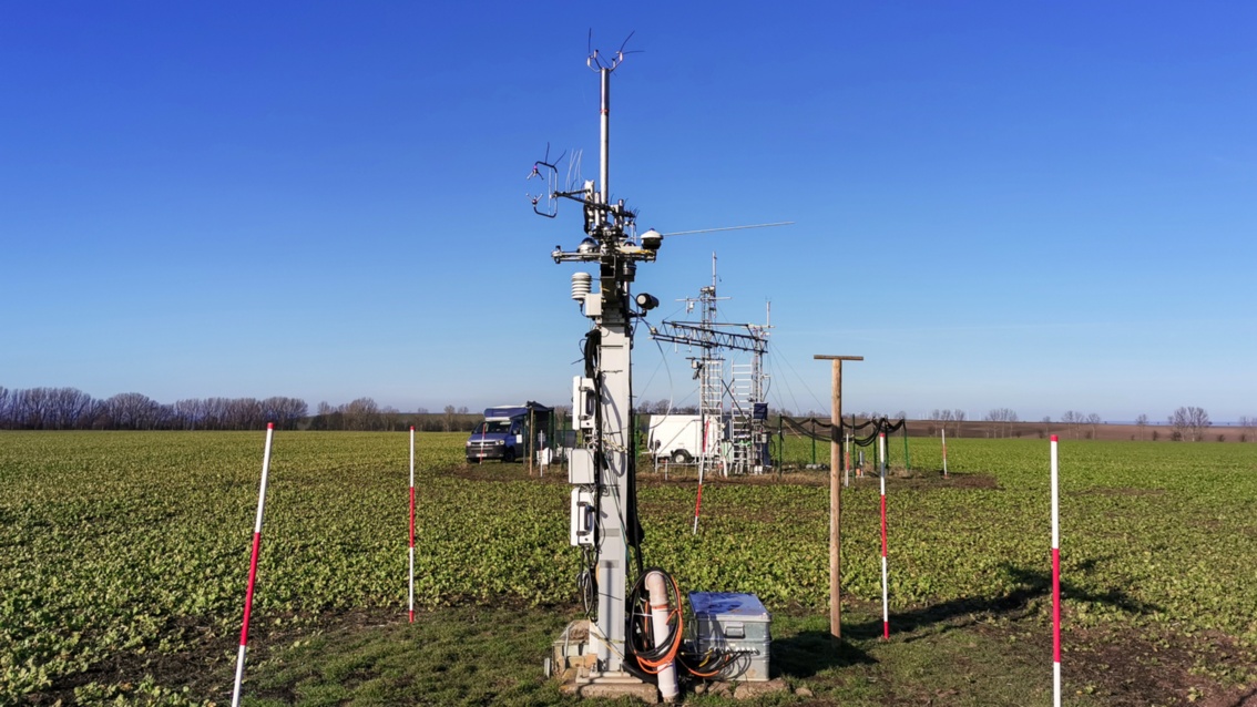 Auf einem Feld sind technische Geräte installiert, die an alte Rundfunk-Antennen erinnern.