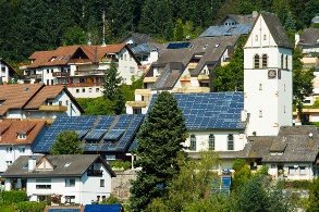 Photovoltaik-Module auf den Dächern Schönaus, in der Mitte die Kirche