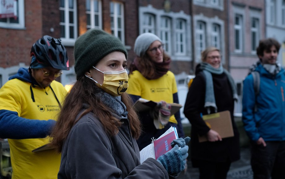 Eine Gruppe von fünf Leuten steht mit Klemmbrettern auf der Straße