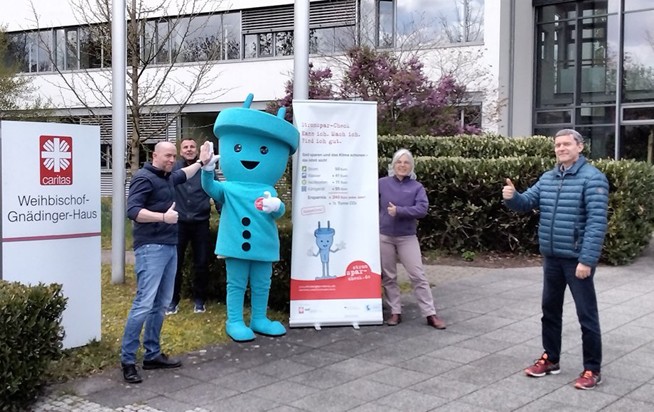 Gruppenbild der Stromspar-Check-Organisatoren vor Caritas-Zentrale mit Maskottchen Stecky