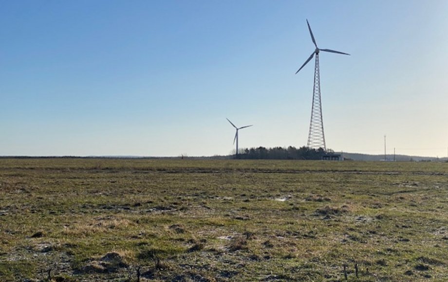 Weite Landschaft, aus der sich zwei Windkraftanlagen erheben