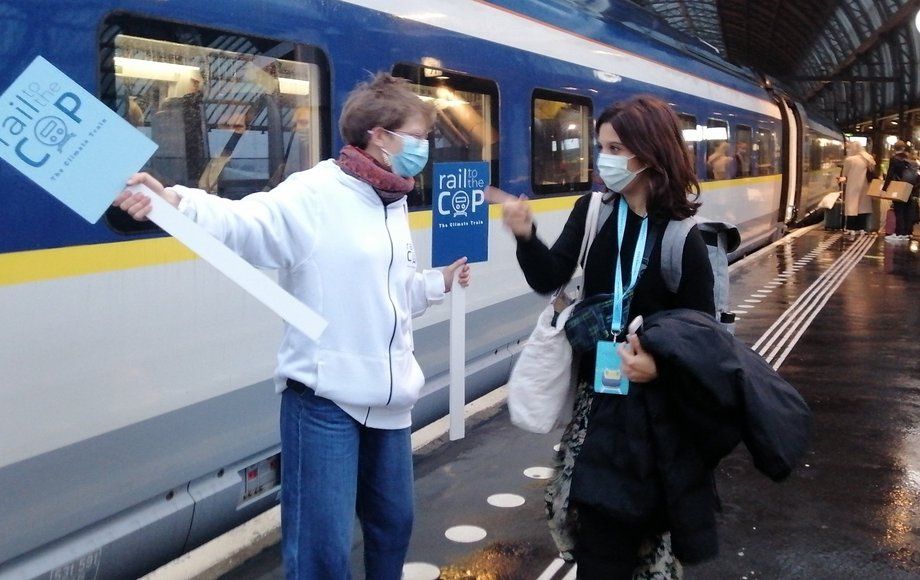 Zwei Personen am Bahnsteig vor einem Zug.