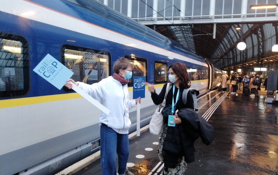 Zwei Personen am Bahnsteig vor einem Zug.