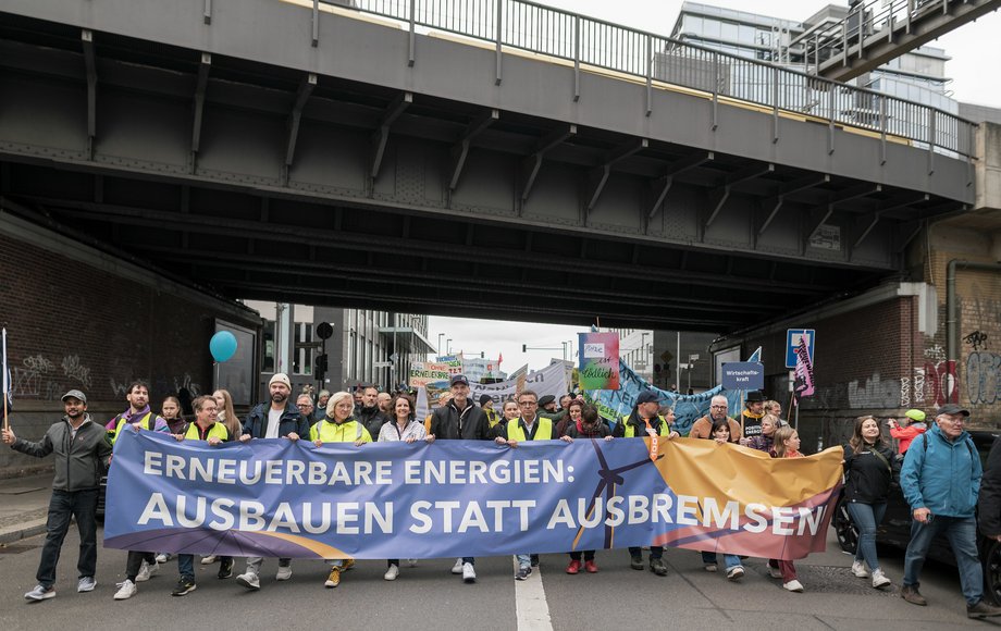 Demozug läuft unter Eisenbahnbrücke durch