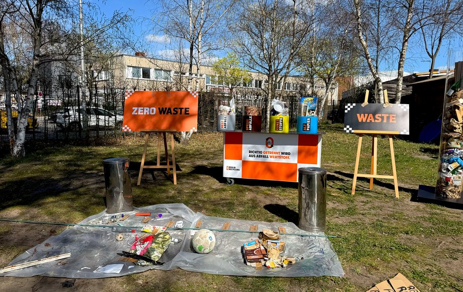 Auf einem Platz liegen Plastikplanen mit Müllfunden, dazu Infotafeln