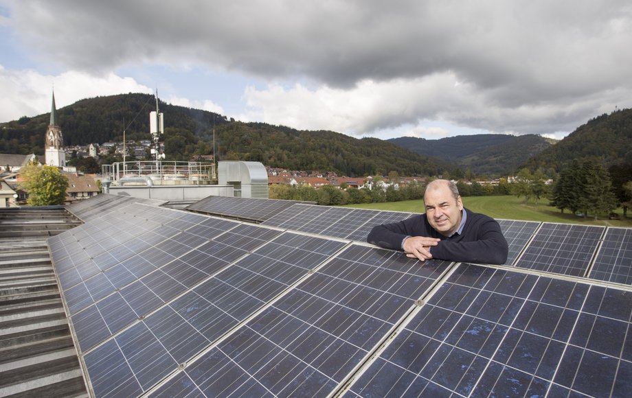 Stefan Ganzmann auf einem Dach, das mit einer Photovoltaik-Anlage ausgestattet ist.