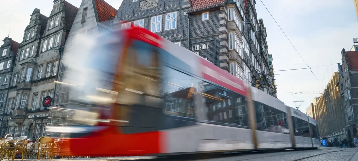 Eine Straßenbahn fährt durch die Bremer Altstadt, wegen ihrer Bewegung ist sie unscharf zu sehen