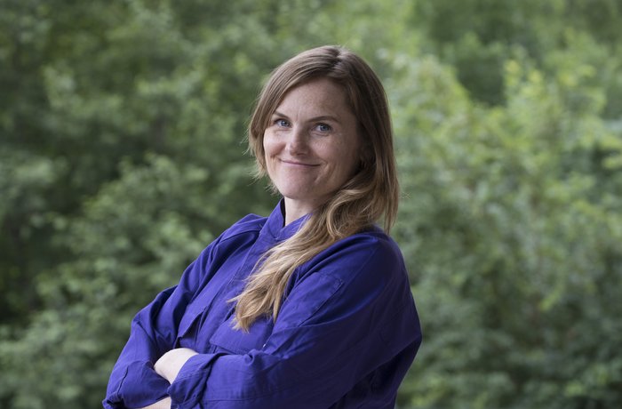 Cesy Leonard im Overall vor Büschen