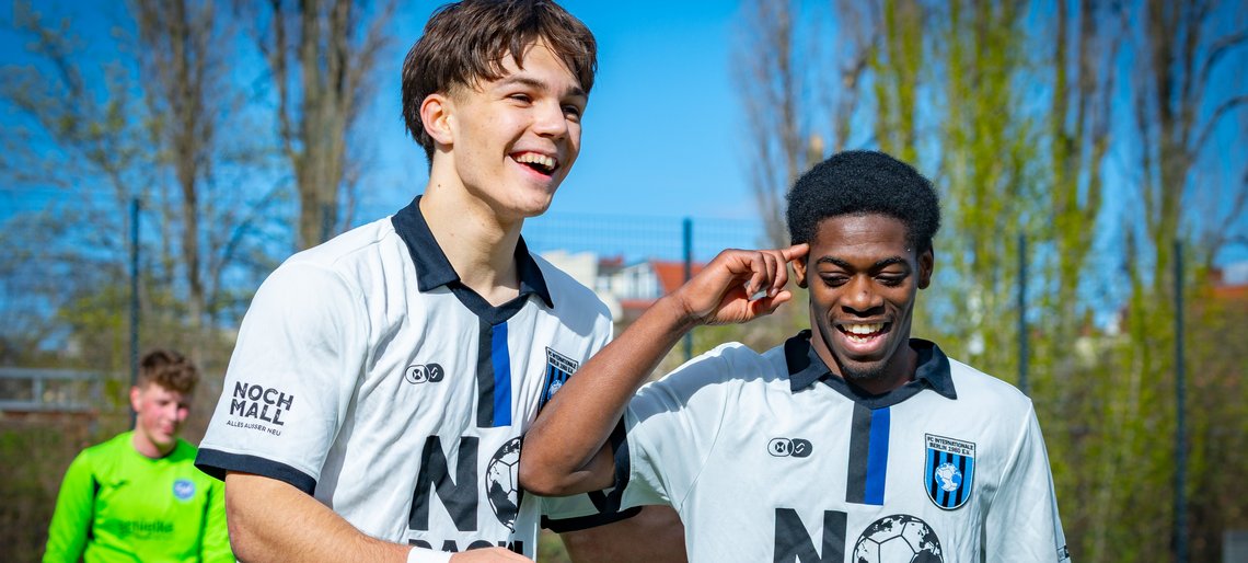 Zwei Jungen in Fußballtrikots auf dem Spielfeld