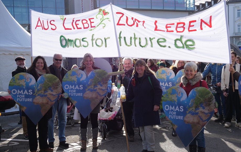 Gruppe steht unter einem Banner mit der Aufschrift "Aus Liebe zum Leben – Omas For Future"