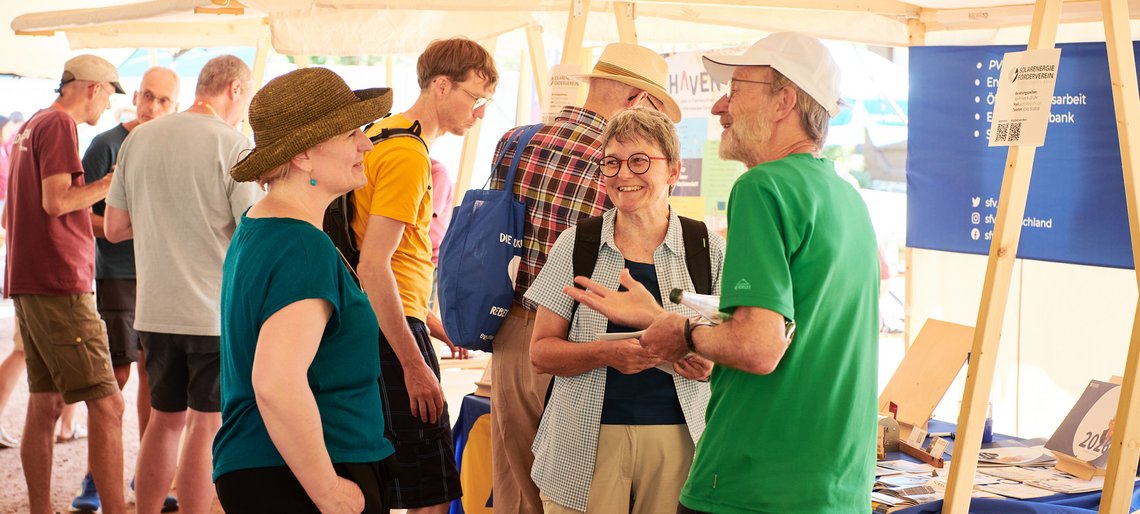 Gruppe von Menschen steht an Marktständen