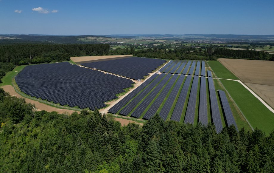 Luftaufnahme des EWS-Solarparks Döggingen 2 mit großflächigen Solarmodulen inmitten von Wald und Feldern.