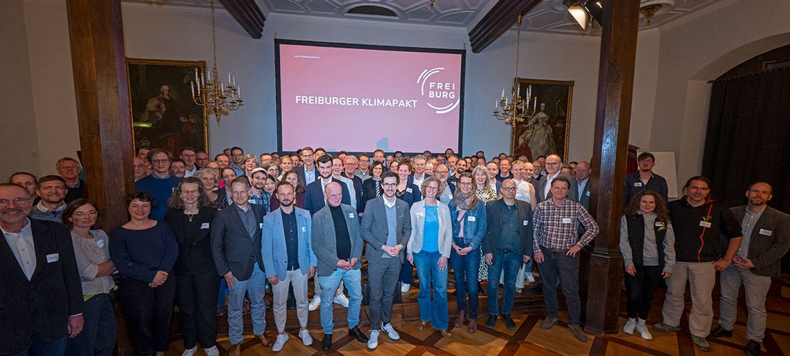 Zu sehen ist eine Gruppe von Mitgliedern des Freiburger Klimapaktes in einem Saal im Historischen Kaufhaus in Freiburg.