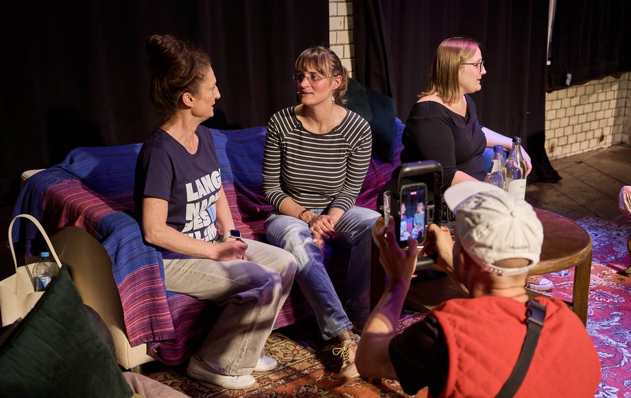 Drei Frauen nebeneinander auf einem Sofa.