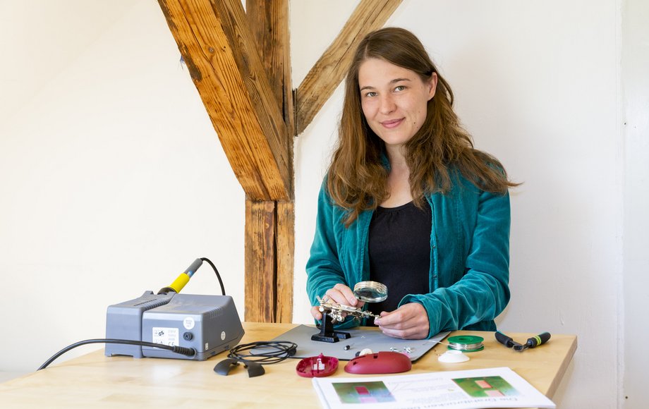 Lena Becker mit Elektroteilen und Lötzubehör