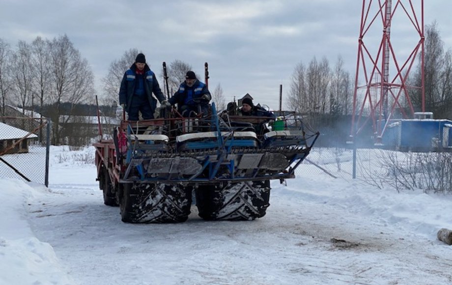 Drei Männer fahren auf einem Quad durch eine verschneite Landschaft