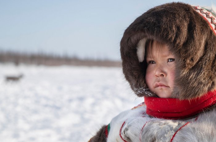 Ein Inuit-Kind in Schneelandschaft.