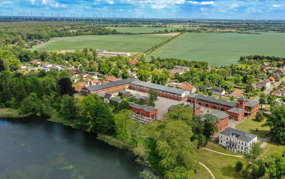 Luftaufnahme mit einem See und dem Hotel