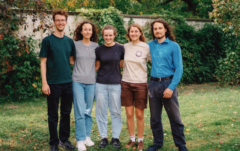 Gruppenfoto von fünf Menschen in einem Garten.