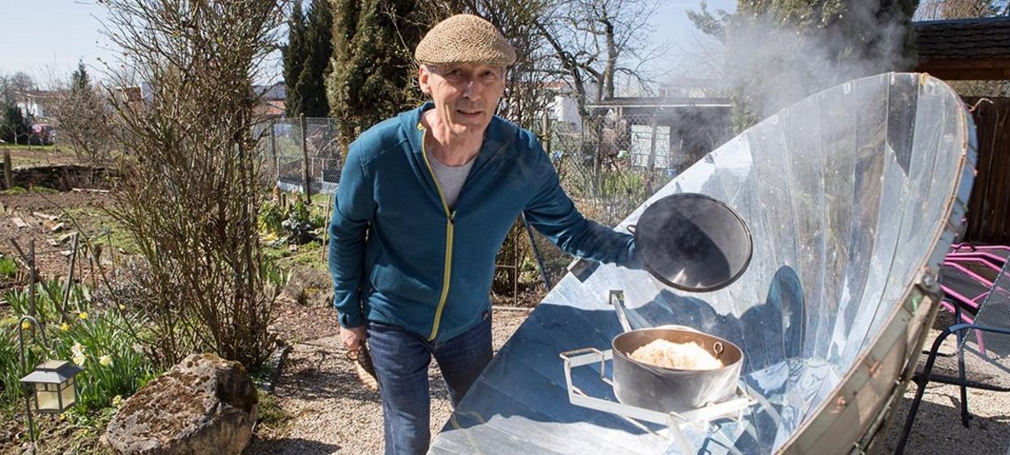 Der Solarbäcker hebt den Deckel seines Ofens – Dampf steigt auf