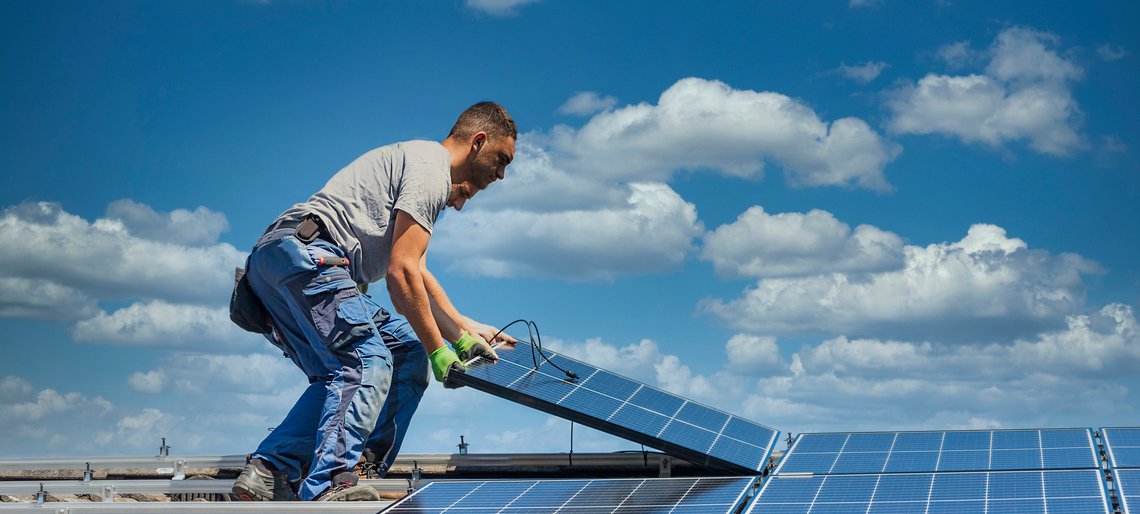 Techniker installieren Solarmodule auf einem Dach.