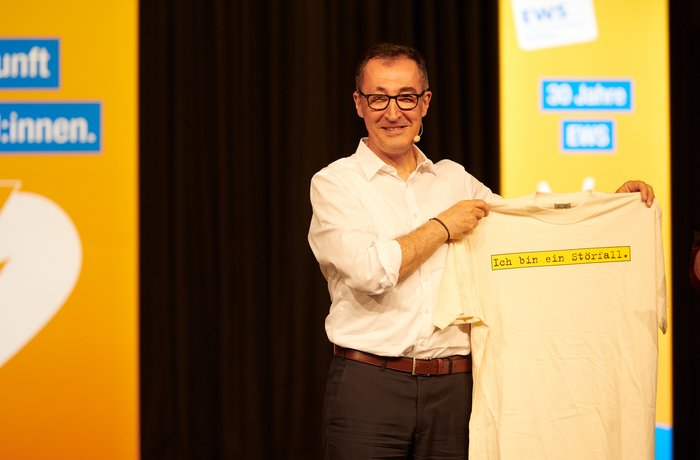 Cem Özdemir hält ein T-Shirt mit der Aufschrift "Ich bin ein Störfall" hoch