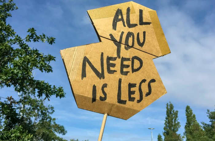 Demoschild „All you need is less“