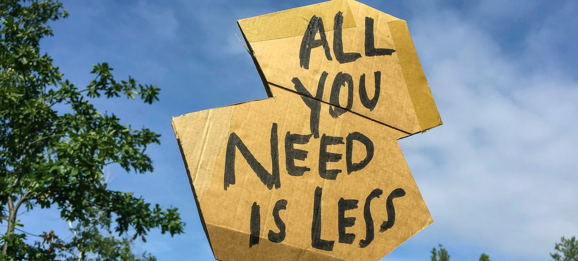 Demoschild „All you need is less“