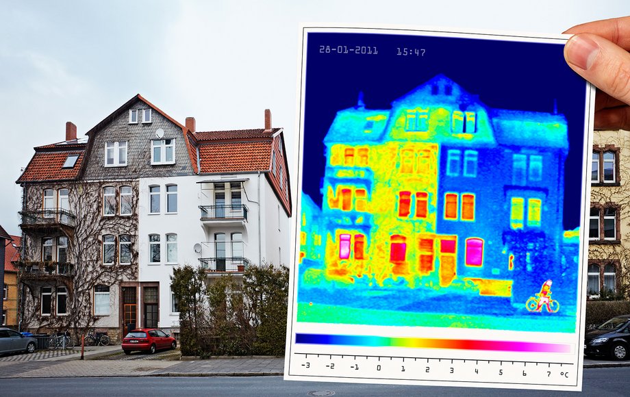 Ein halb isoliertes Gebäude, davor wird der Ausdruck eines Wärmebilds gehalten, das den Unterschied zwischen saniert und unsaniert zeigt