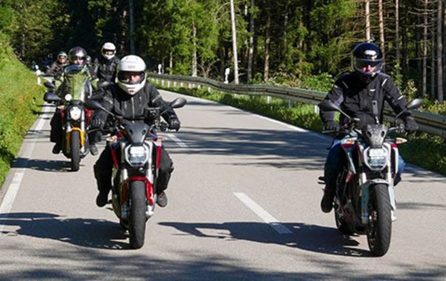 Drei Motorradfahrer fahren durch den Wald