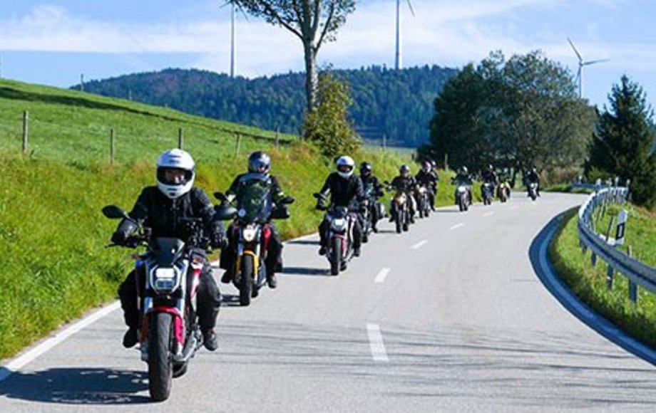 Kette von Motorradfahrern auf Landstraße