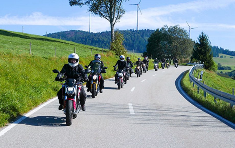 Kette von Motorradfahrern auf Landstraße