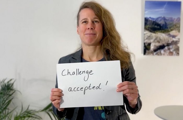 Frau hält Schild: Challenge accepted