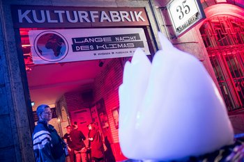 Stimmungsvoll ausgeleuchteter Eingang, vor dem ein großer Eisberg steht