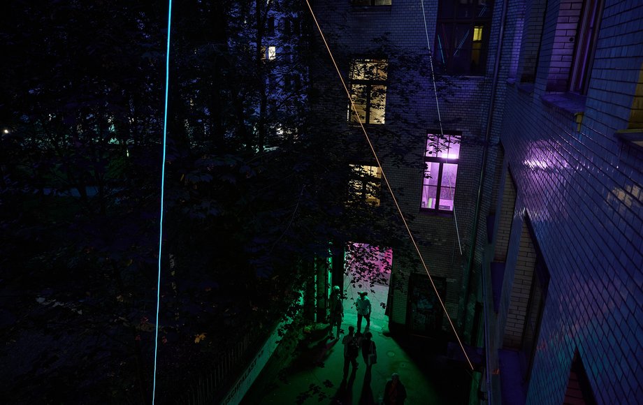 Blick von oben in einen nächtlichen Innenhof, mit bunten Lichtern und Leuchtschnüren in stimmungsvolle Atmosphäre getaucht.