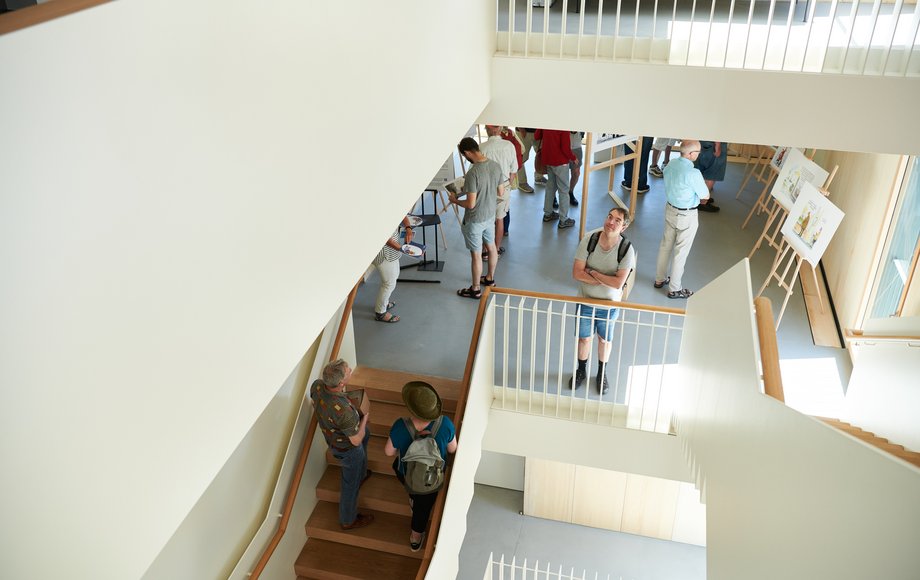 Blick in ein großes Treppenhaus, auf dem Menschen auf- und absteigen