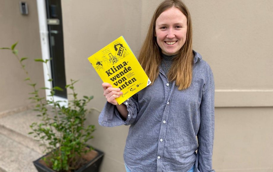 Frau präsentiert lächelnd ein Buch