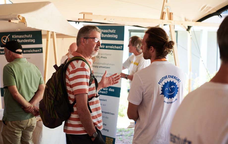 Menschen an einem Marktstand unterhalten sich.