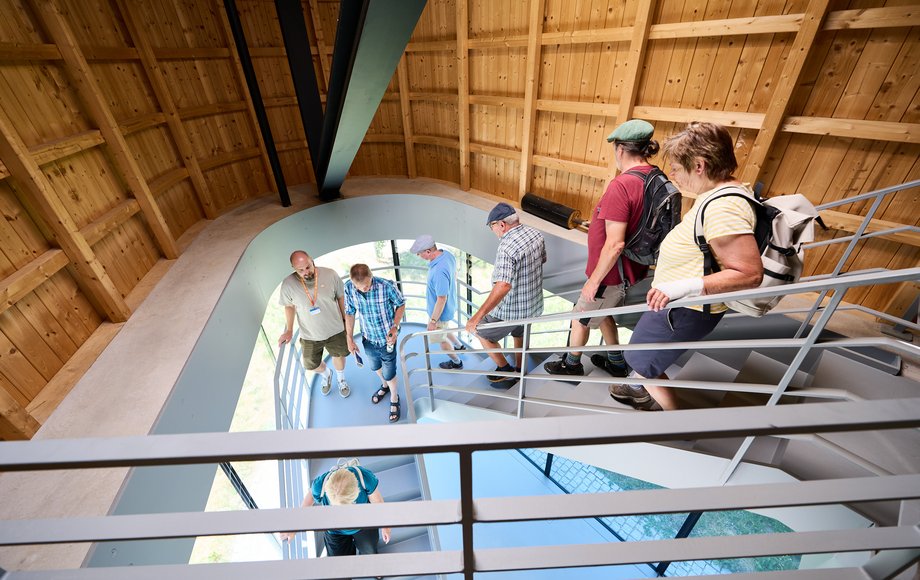 Blick auf eine Treppe, wo eine Gruppe Menschen herabsteigt.