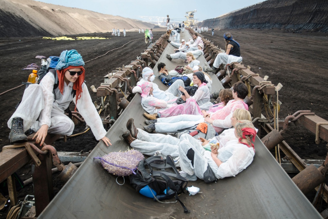 Aktivisten ruhen sich auf Kohle-Förderbändern im Tagebau aus.