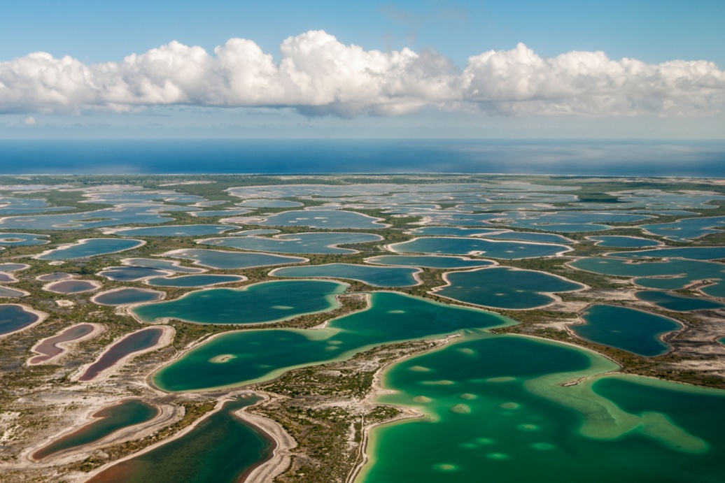 Luftaufnahme deas Atolls Kiritimati mit seichtem Gewässer zwischen karstigem Land