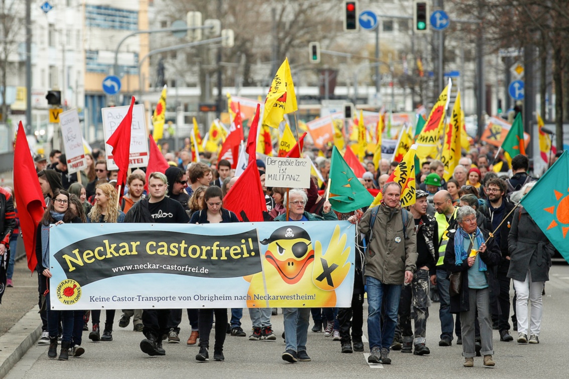 Eine Gruppe Demonstraten mit Anti-Atomkraft-Fahnen trägt ein großes Banner mit der Aufschrift «Neckar castorfrei» vor sich her.