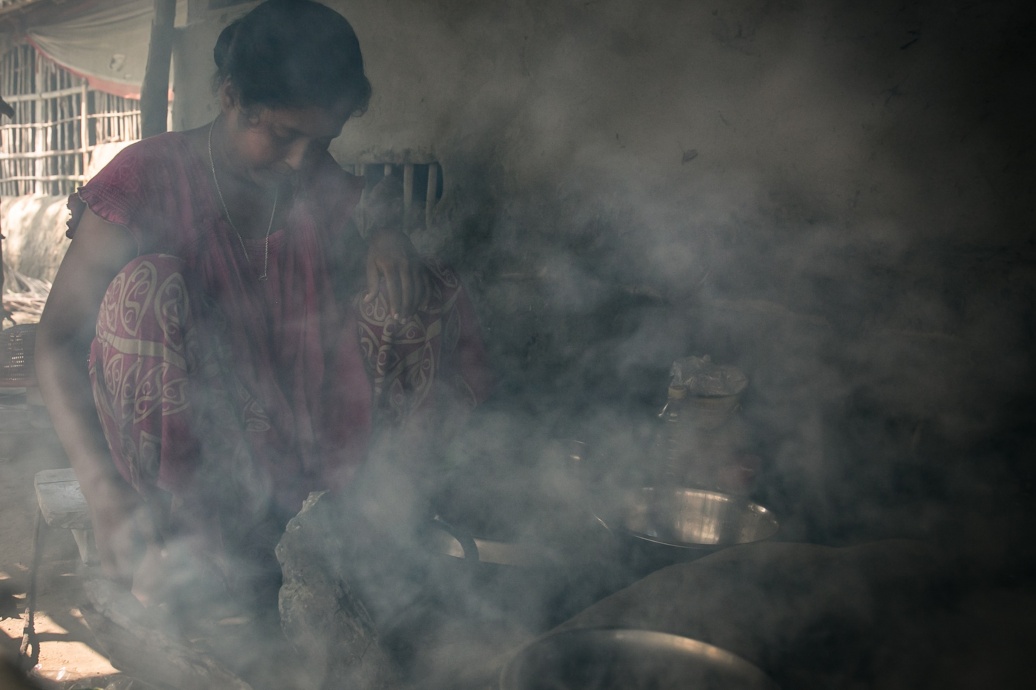 Eine Frau kocht und ist eingehüllt von Rauch