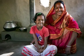 Indische Frau mit Kind vor effizientem Lehmherd