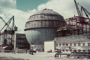 Farbfoto von 1957  in antiquiertem Kolorit zeigt die Baustelle des Atomkraftwerkes; der Kühlbehälter ist kugelrund.
